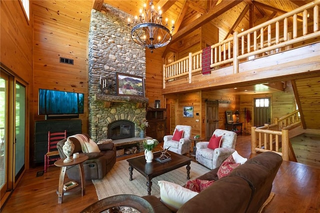 living room with a fireplace, high vaulted ceiling, wood walls, and hardwood / wood-style flooring