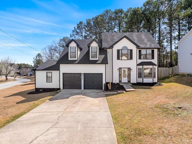 view of front facade with a front lawn, an attached garage, fence, and driveway