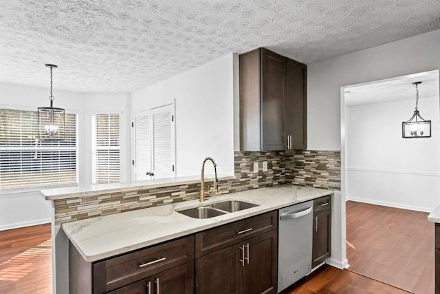 kitchen featuring dishwasher, light stone counters, dark wood-style flooring, and a sink