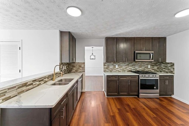 kitchen with a sink, dark wood-type flooring, appliances with stainless steel finishes, and dark brown cabinets