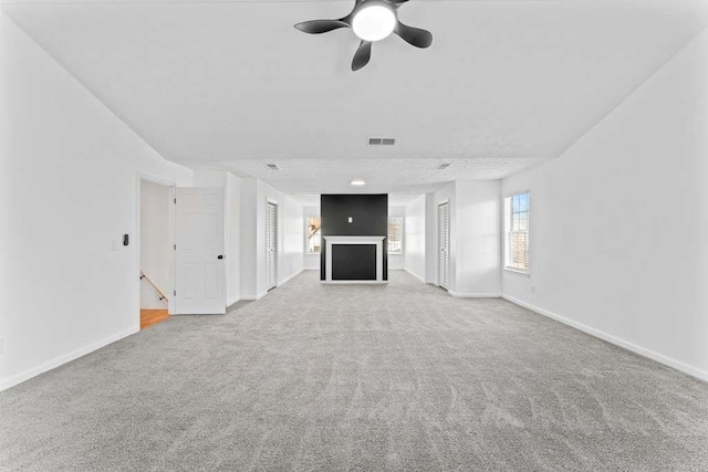 unfurnished living room with carpet flooring, baseboards, and visible vents