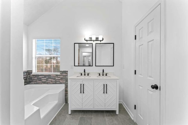 bathroom featuring a bath, double vanity, lofted ceiling, and a sink