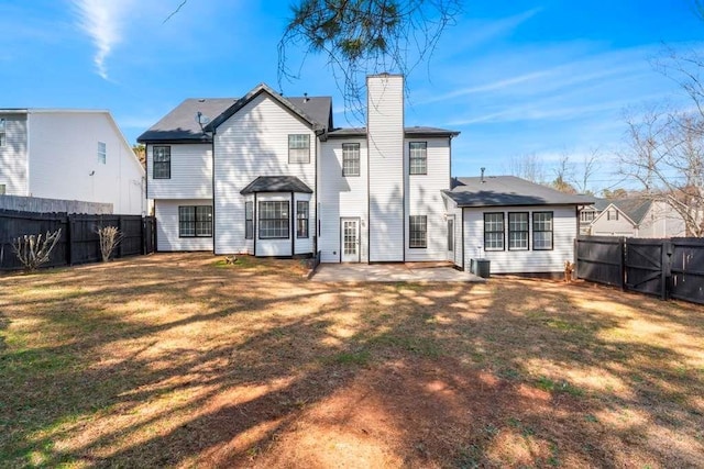 rear view of property with a yard, central AC unit, a chimney, and a fenced backyard