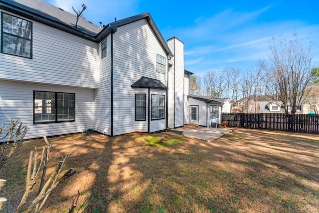 back of property featuring a yard, a patio, and fence