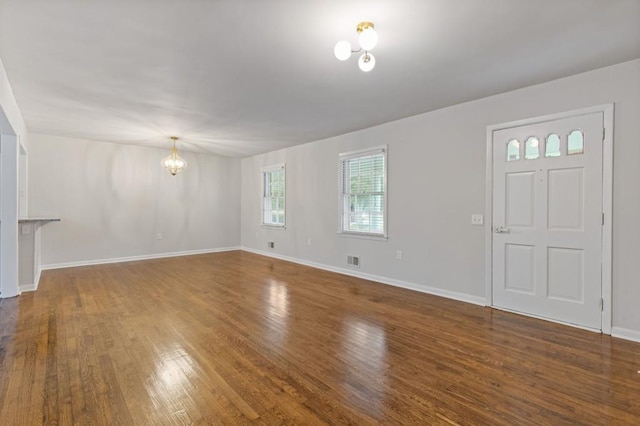 256 Teresa Ln, Loganville, GA 30052 - unfurnished living room featuring a chandelier, wood finished floors, and baseboards