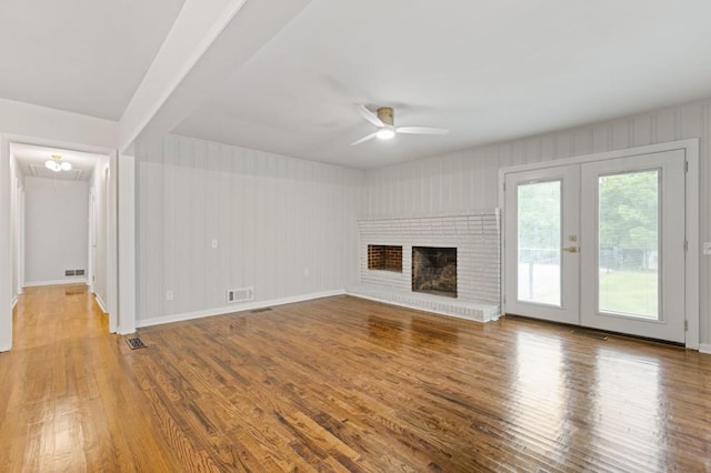 256 Teresa Ln, Loganville, GA 30052 - unfurnished living room with ceiling fan, wood finished floors, french doors, a fireplace, and baseboards