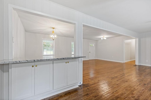 256 Teresa Ln, Loganville, GA 30052 - kitchen with dark wood-type flooring, open floor plan, a chandelier, and light stone counters