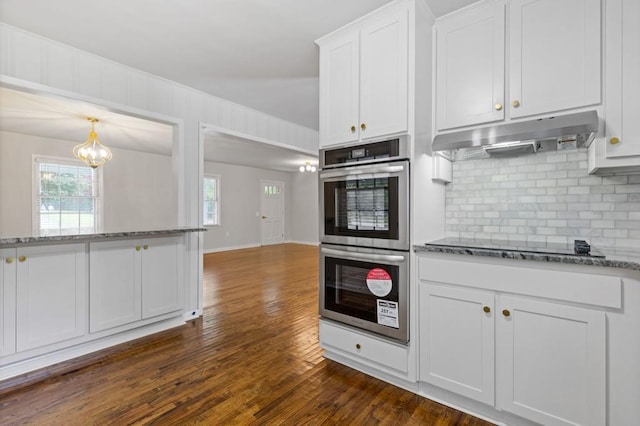256 Teresa Ln, Loganville, GA 30052 - kitchen with double oven, under cabinet range hood, backsplash, and dark wood-type flooring