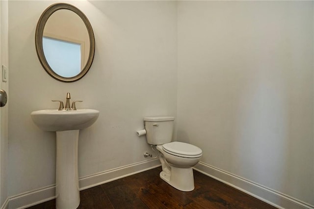 bathroom featuring toilet, hardwood / wood-style floors, and sink