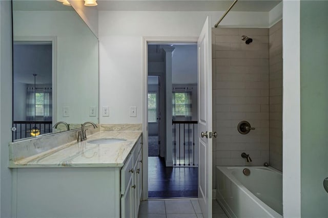 bathroom featuring vanity, tiled shower / bath combo, and tile patterned flooring