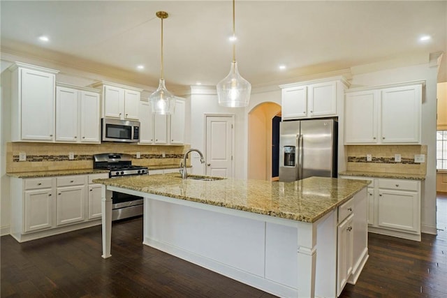 kitchen with dark hardwood / wood-style flooring, a kitchen island with sink, sink, pendant lighting, and stainless steel appliances