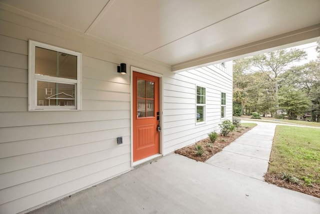 view of exterior entry with a yard