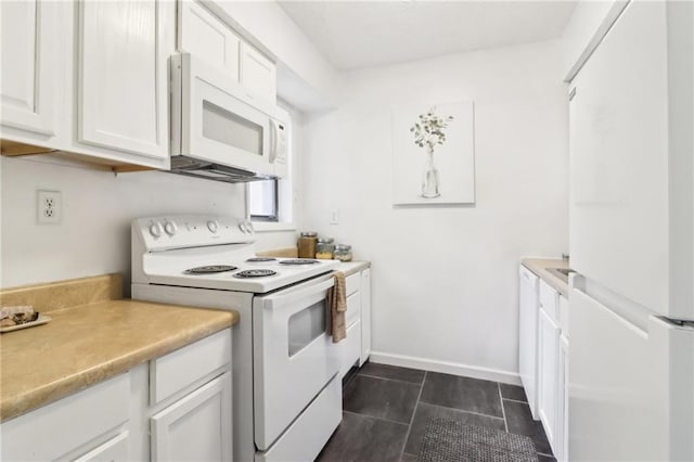 kitchen featuring white cabinetry, white appliances, and dark tile patterned floors