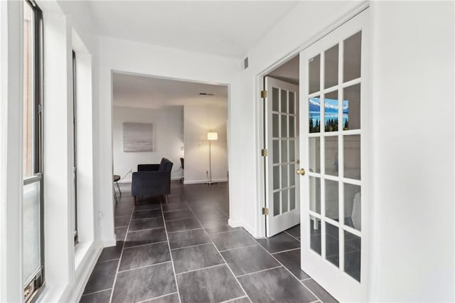 hall featuring french doors and dark tile patterned floors