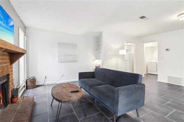 living room with a brick fireplace and washer / dryer