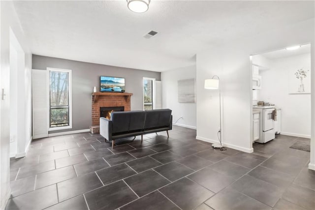 tiled living room featuring a brick fireplace