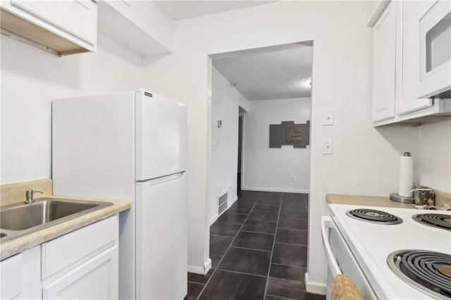 kitchen featuring sink, white cabinets, white appliances, and dark tile patterned flooring