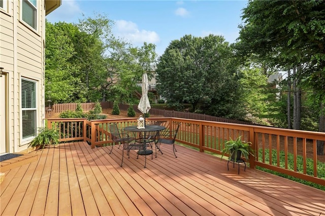 deck featuring outdoor dining area and a fenced backyard