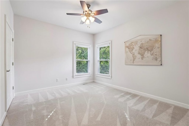 spare room with carpet flooring, baseboards, and ceiling fan