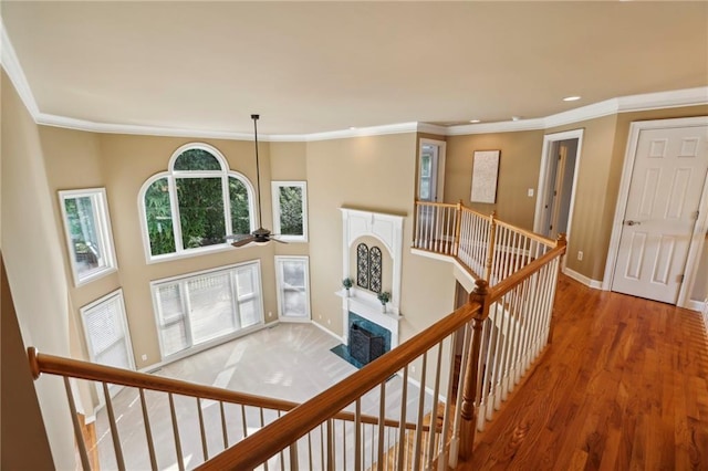 hall featuring baseboards, crown molding, and an upstairs landing