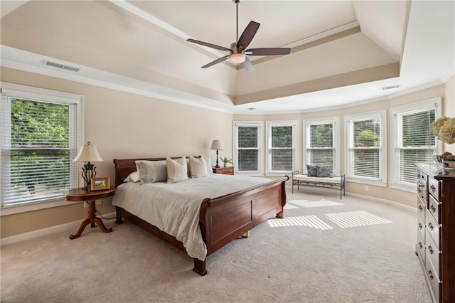 bedroom featuring visible vents, light carpet, and a raised ceiling
