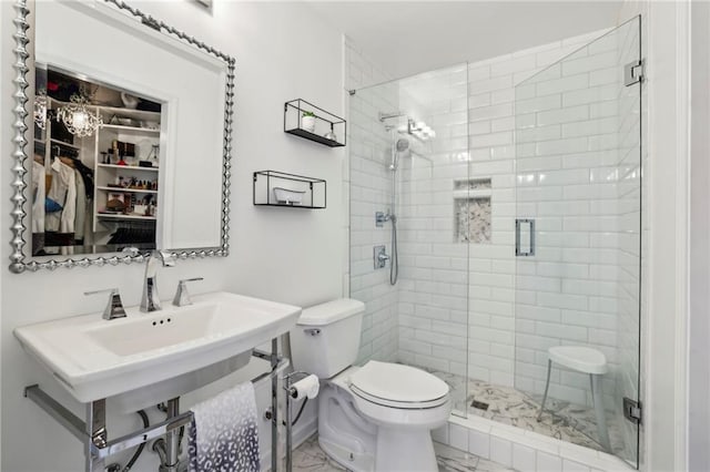 bathroom with a stall shower, toilet, and marble finish floor