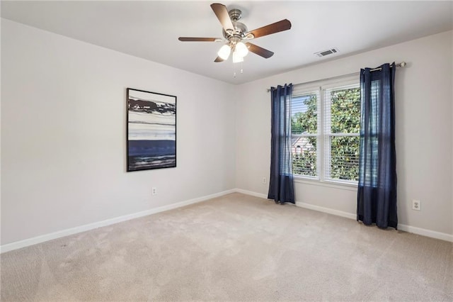 empty room featuring baseboards, a ceiling fan, light colored carpet, and visible vents