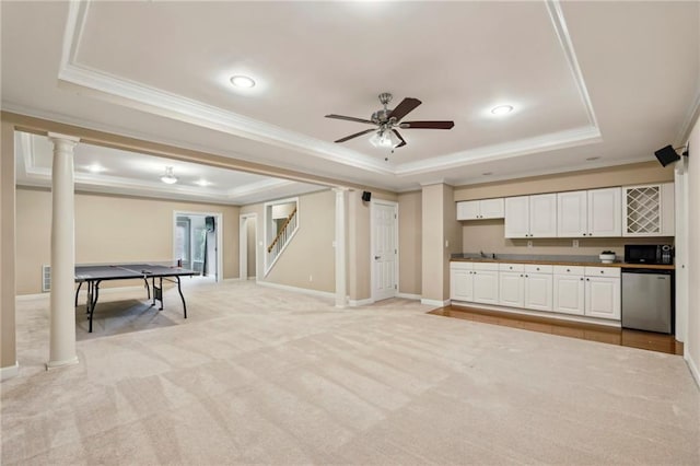 playroom featuring a raised ceiling, ornamental molding, and ornate columns