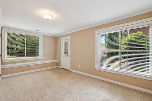 carpeted empty room with baseboards, ornamental molding, and visible vents