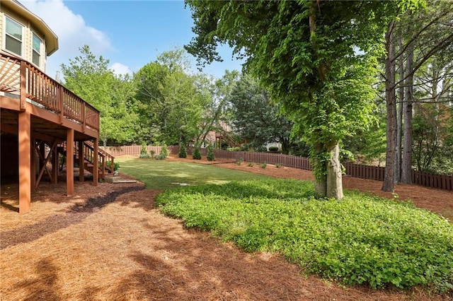 view of yard with a deck, a fenced backyard, and stairs