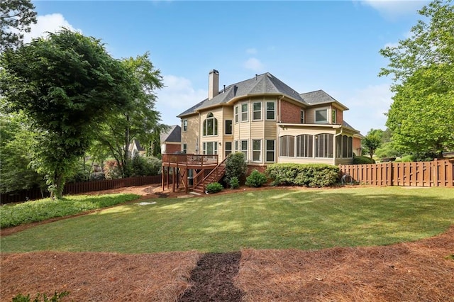 back of property featuring stairway, a chimney, a fenced backyard, and a sunroom