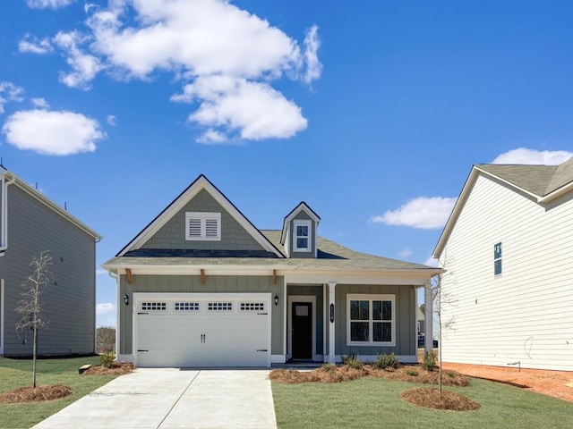 view of front of home with driveway, a front lawn, board and batten siding, and an attached garage