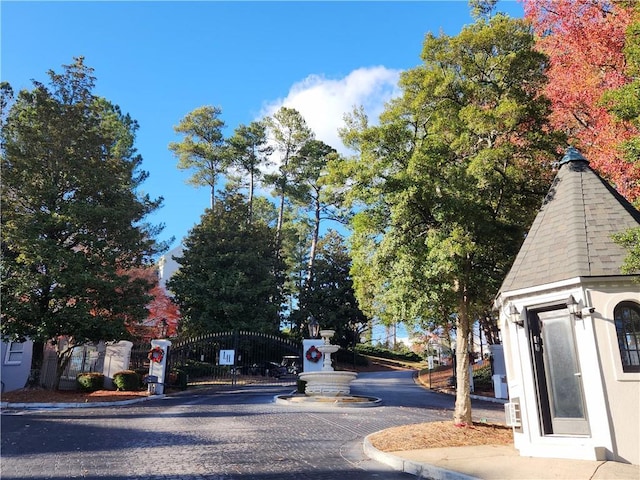 view of street featuring a gate and curbs