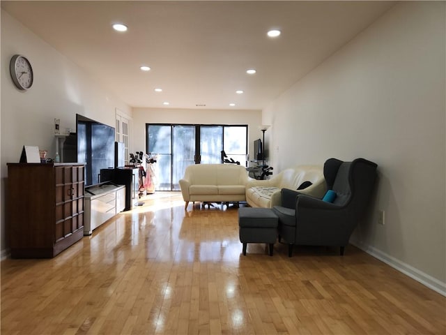 living area featuring baseboards, recessed lighting, and light wood-style floors