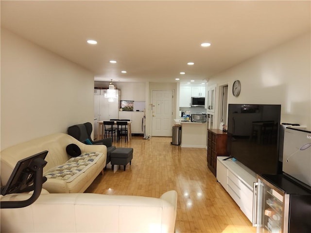 living room featuring light wood-type flooring, beverage cooler, and recessed lighting