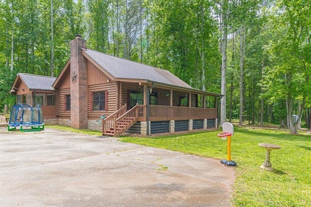 log home with a front yard and a trampoline