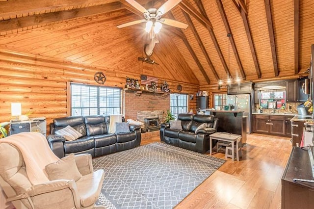 living room featuring light wood-type flooring, wood ceiling, ceiling fan, log walls, and vaulted ceiling with beams