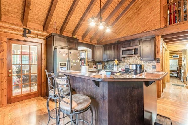 kitchen featuring beam ceiling, wooden ceiling, high vaulted ceiling, appliances with stainless steel finishes, and light wood-type flooring