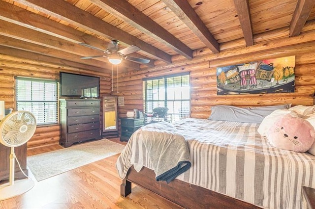 bedroom with log walls, wooden ceiling, and beamed ceiling