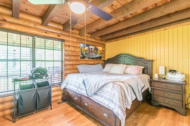 bedroom featuring wood ceiling, ceiling fan, log walls, beamed ceiling, and light hardwood / wood-style floors