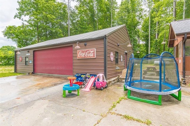 view of outdoor structure featuring a garage and a trampoline