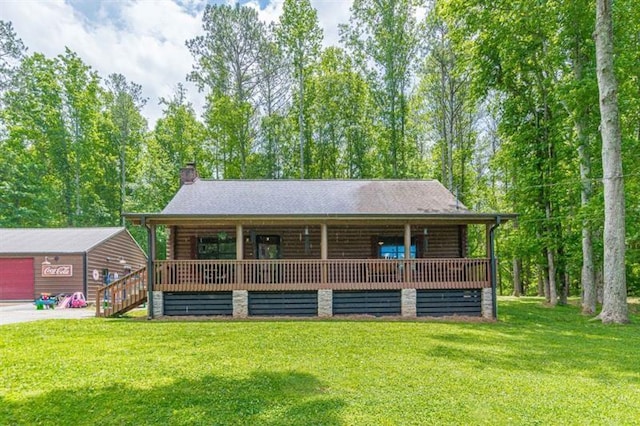 rear view of property featuring a garage and a yard