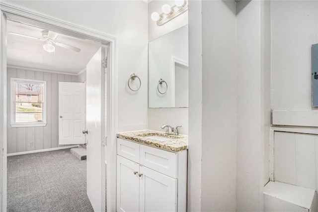 bathroom with crown molding, vanity, and a ceiling fan