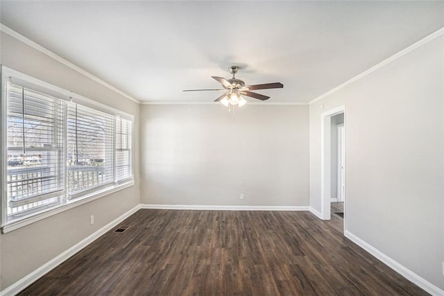 empty room featuring dark wood-type flooring, visible vents, ornamental molding, and baseboards