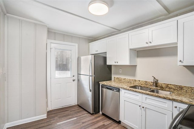 kitchen with white cabinets, dark wood-type flooring, light stone countertops, stainless steel appliances, and a sink