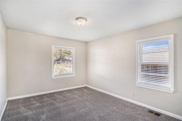 carpeted spare room with visible vents and baseboards