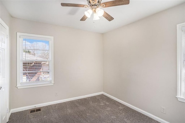 spare room with carpet floors, baseboards, visible vents, and ceiling fan