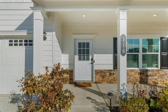 property entrance featuring a porch and a garage