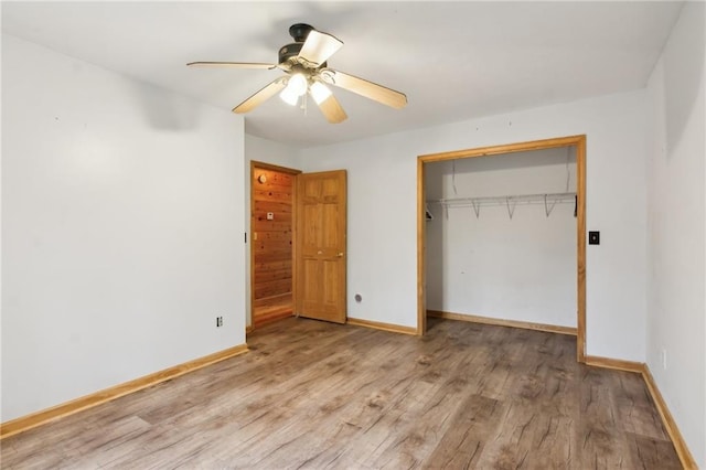 unfurnished bedroom featuring ceiling fan, a closet, baseboards, and wood finished floors