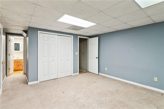 unfurnished room with carpet floors and a drop ceiling